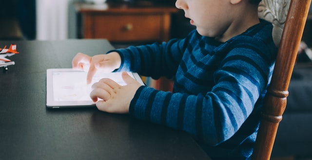 Young Kid Playing Games on a Tablet