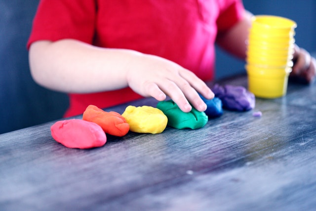 Kid playing with colorful clay