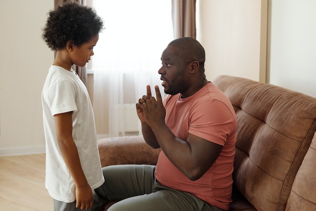 fatherandsonathome Father talking to son in living room