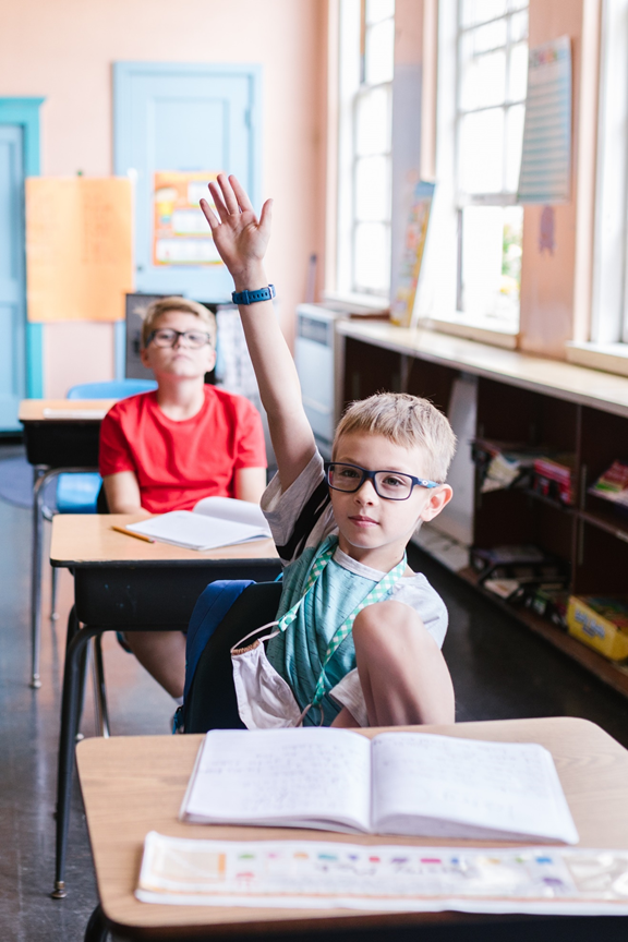 Child raising hand in class