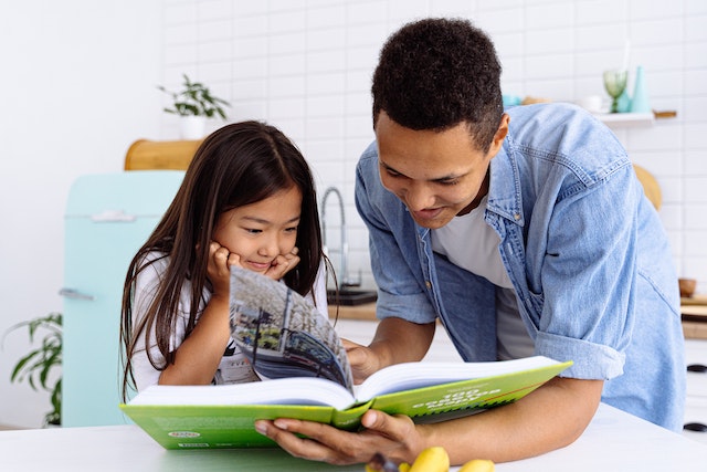 letsexplorethebestparentingbooksyouneedtoreadin Father and daughter reading a book together