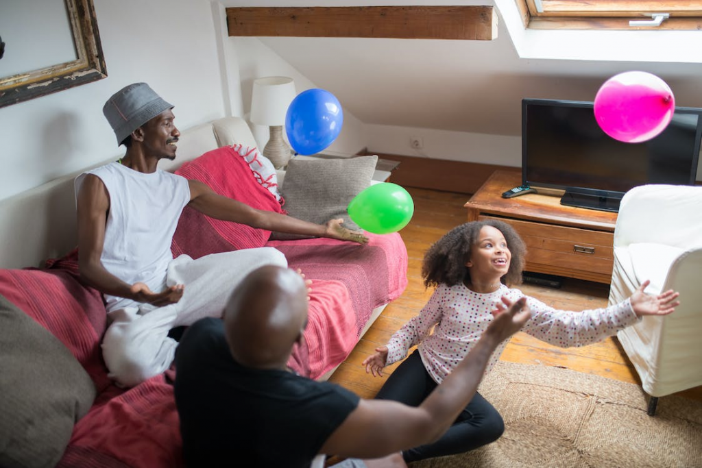 Family playing with balloons in living room