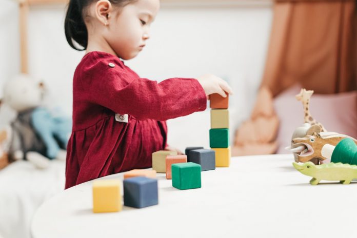 Young girl playing with building blocks