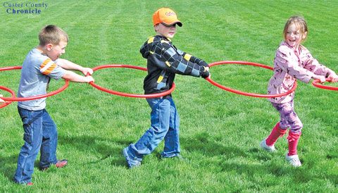 Kids playing game with hula hoops in a field