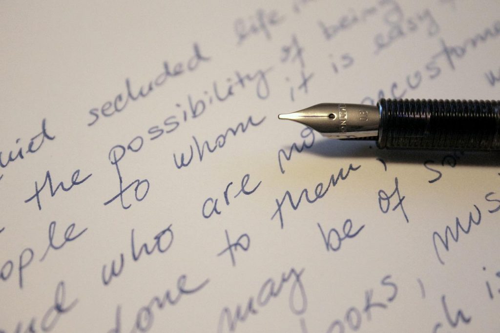 The nib of a fountain pen shown against a page with some writing