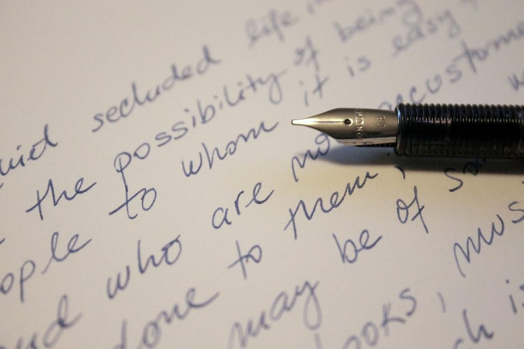 howtoimprovehandwritingineasyways The nib of a fountain pen shown against a page with some writing