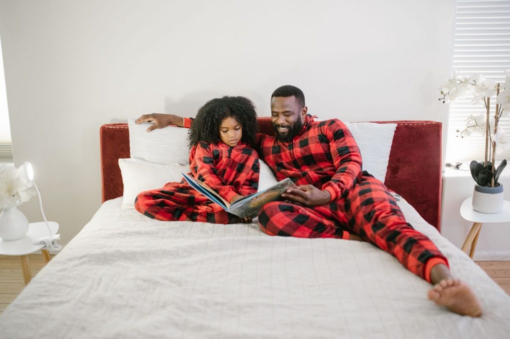 Child reading book with father