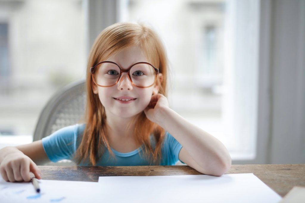Young girl wearing glasses at a desk