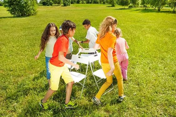 Kids playing musical chairs in a large park