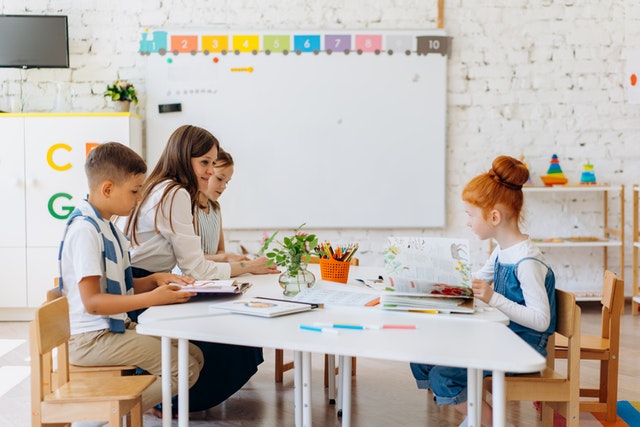 Teacher sitting with her students