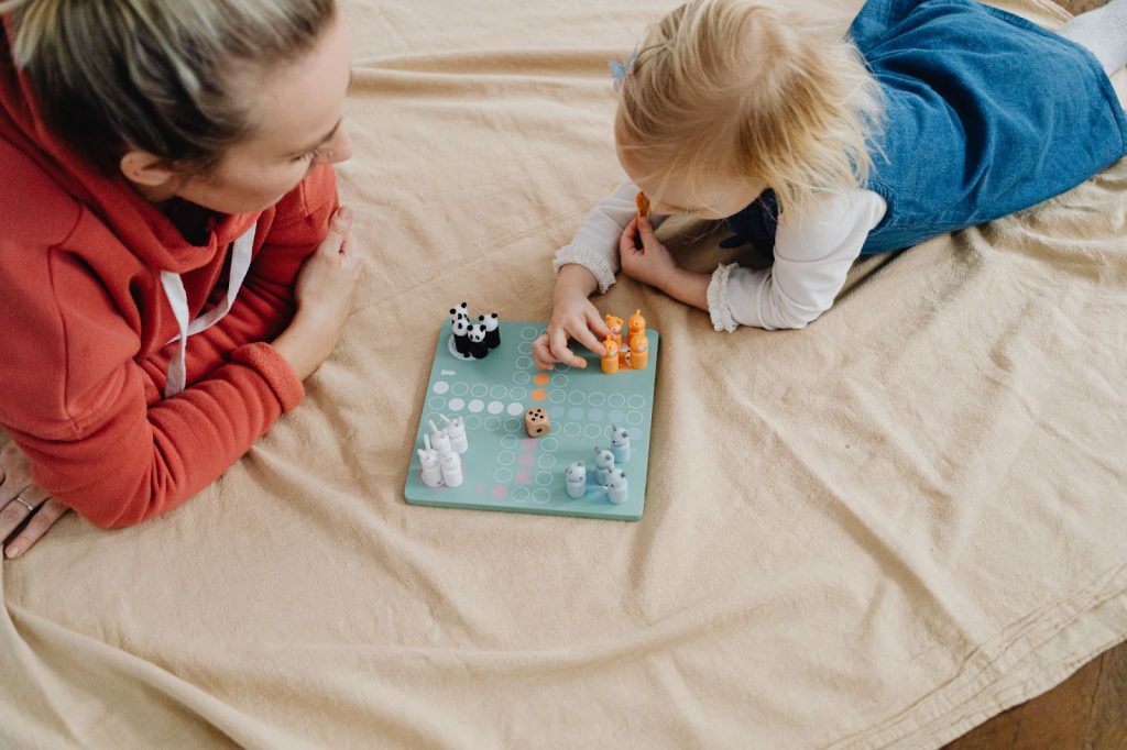 Woman and a young child playing a game in bed