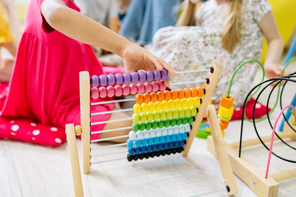 Young child in red dress playing with colorful abacus