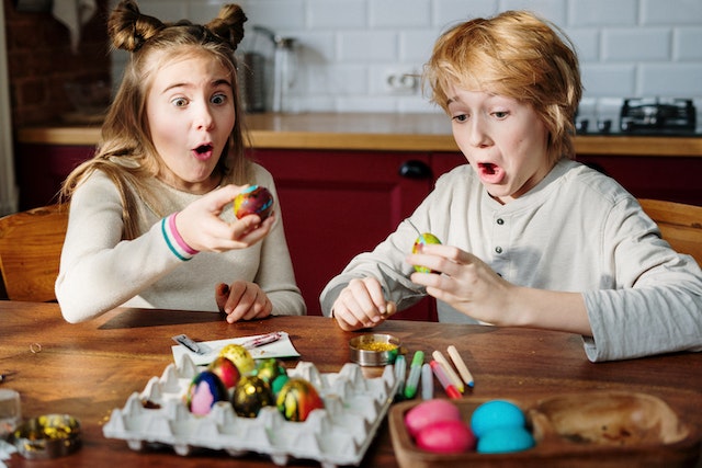 Two kids painting easter eggs