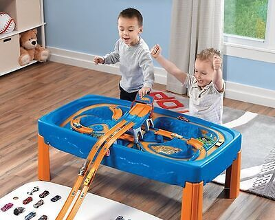 Kids sliding toy cars on plastic race track