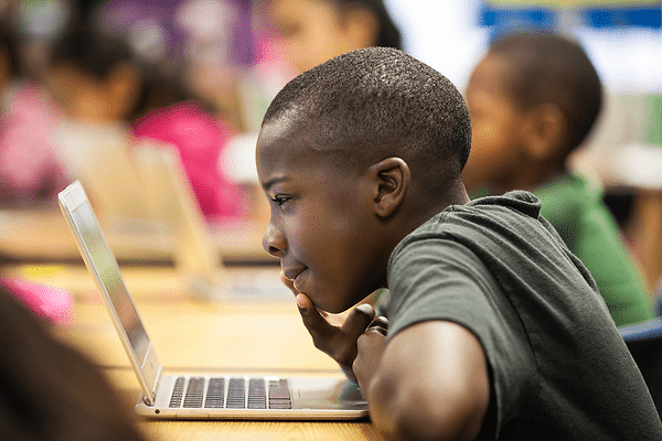 Young boy looking at a computer screen and studying