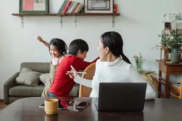 Two kids fool around as their mother turns around to face them