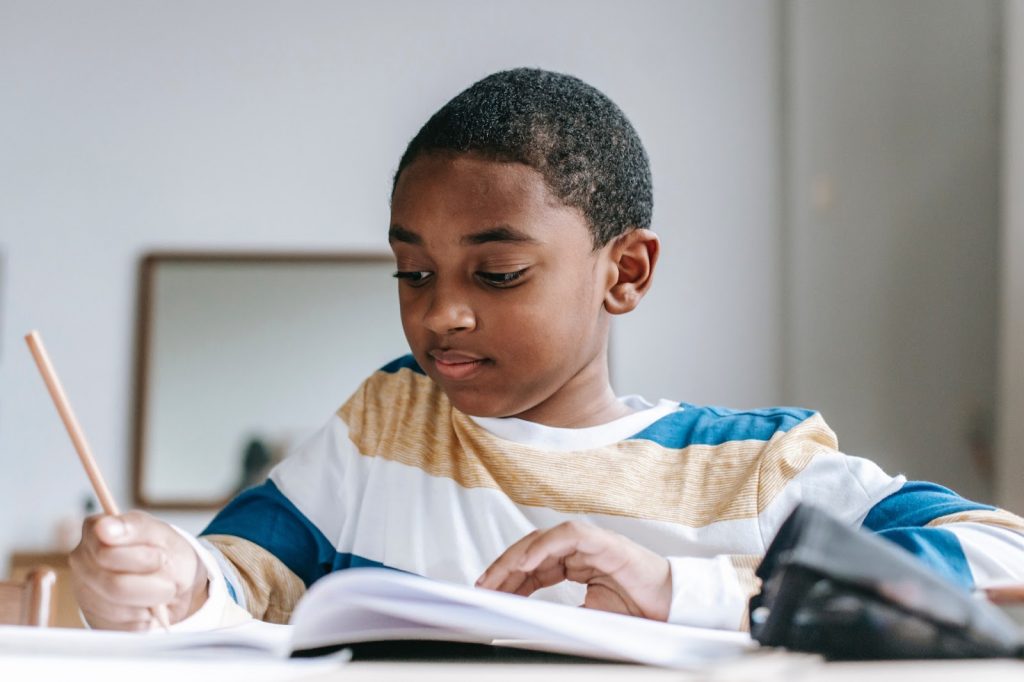 Young boy studying and writing with pencil