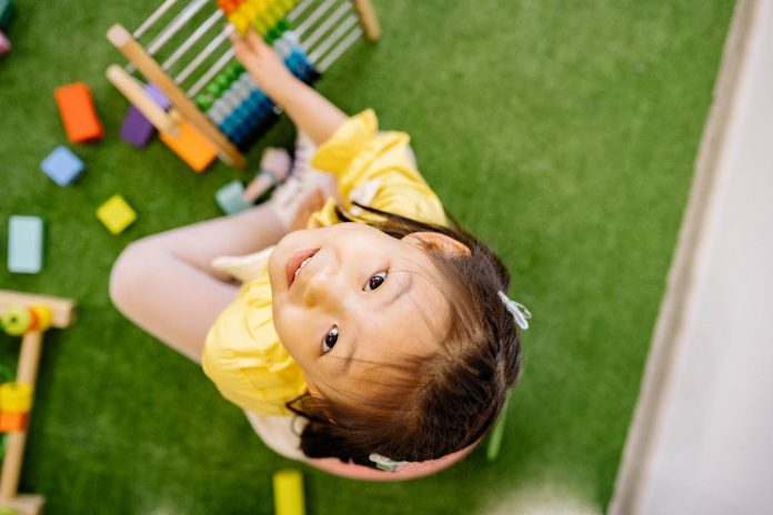 Girl playing abacus sitting on floor