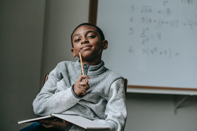 Young boy taking notes and thinking