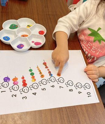 Young child with painting exercise to learn counting