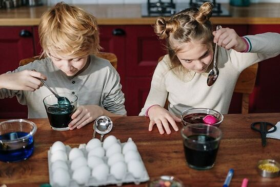 Young kids painting eggs with watercolors