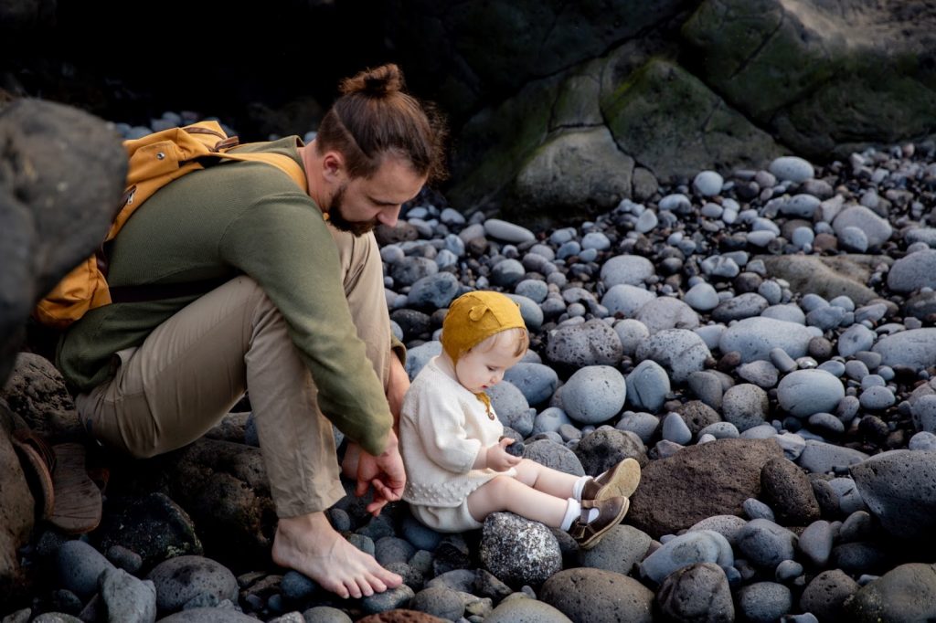 A father and his child sit on some rocks