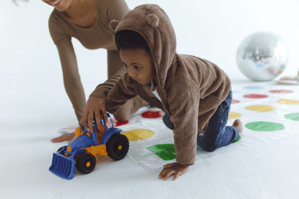 Young boy and mother playing with toy truck