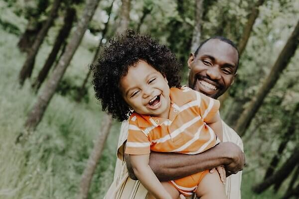 Father holding his son while both laugh