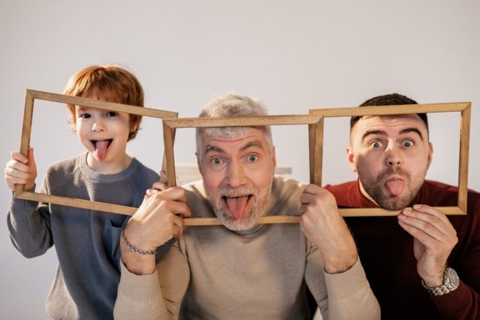 Two adults and a kid playing around with wooden frames