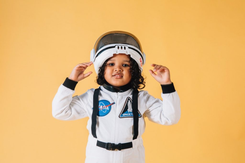 A little girl wearing an astronaut costume