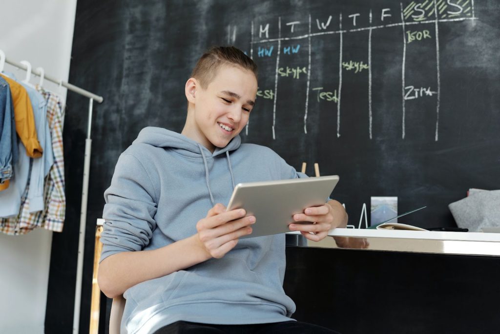 A smiling boy looking at something on a tablet