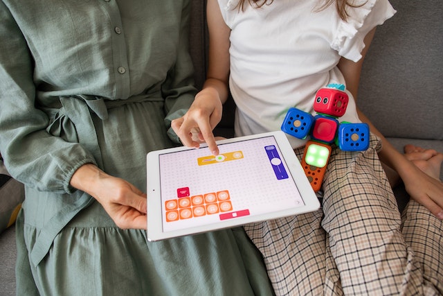 Mother and child playing an educational game on a tablet