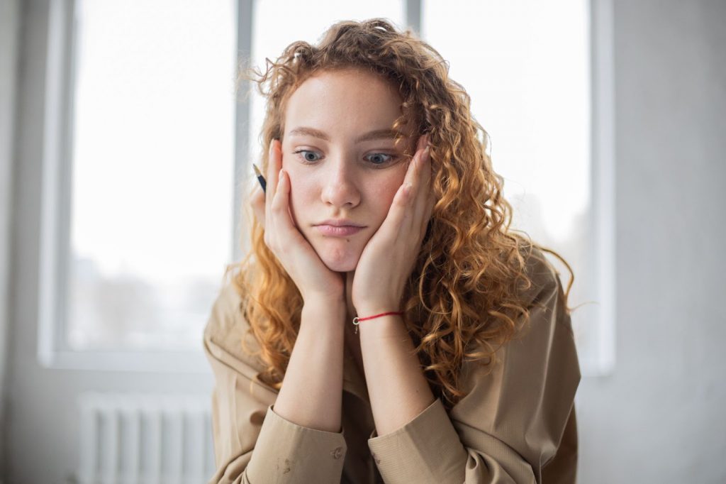 A puzzled girl with a pen in hand