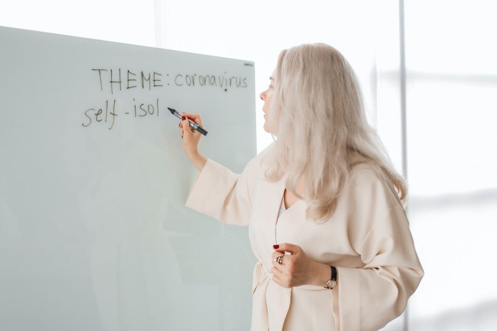 Teacher writing on a whiteboard