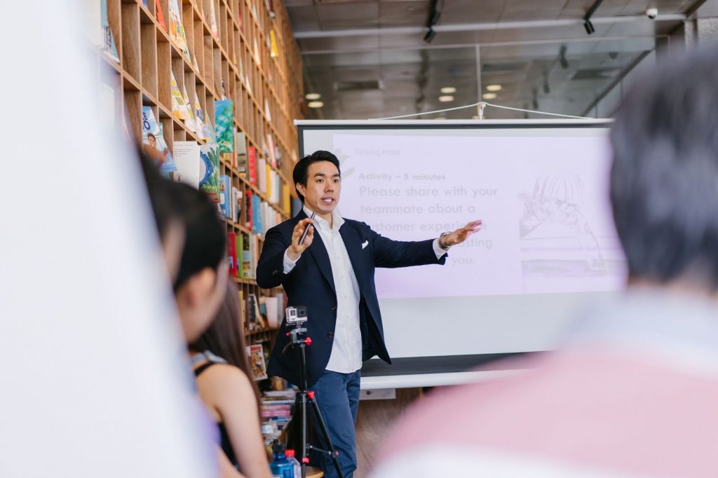 A man in jacket giving a presentation