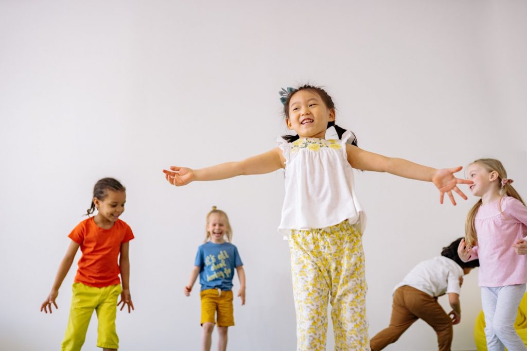 Young children dancing and moving about