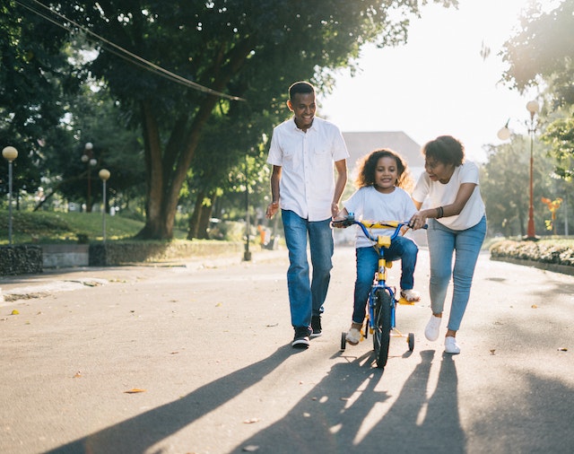 Parents teaching a child to ride a bike