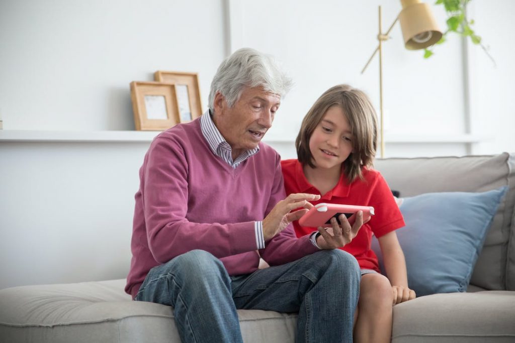 A man showing a child something on a phone