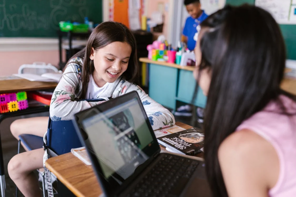 young girls smiling and studying with laptop close shot