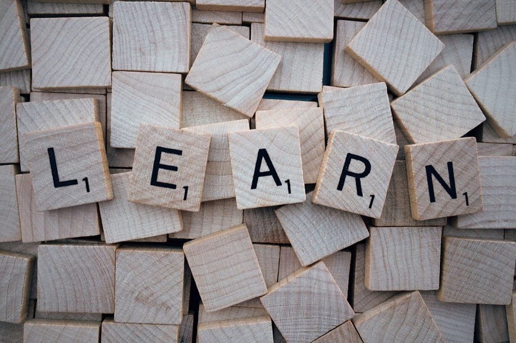 Small wooden blocks with letters are arranged to read learn