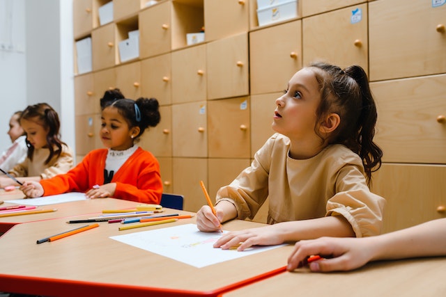 Kids drawing on paper in a classroom