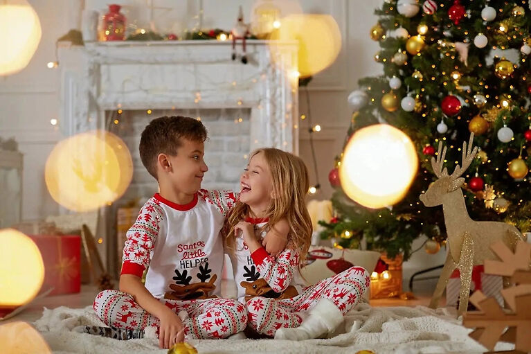 Kids laughing under Christmas tree