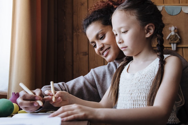 Mother writing kindness notes with daughter