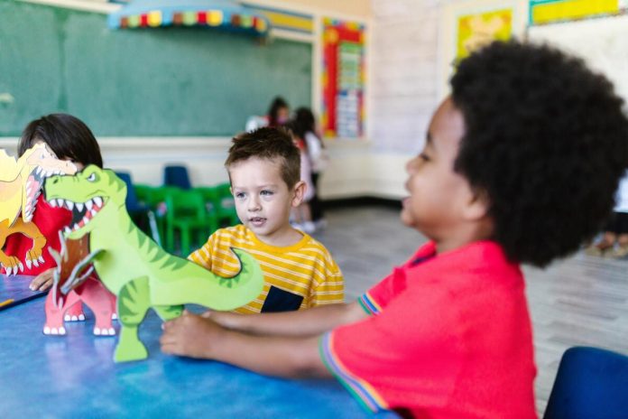 Kids playing with paper dinosaurs