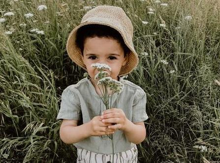A little child smelling flowers