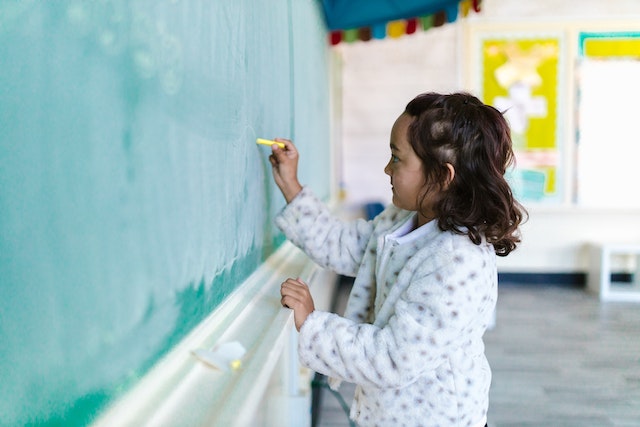 Child writing on a black board