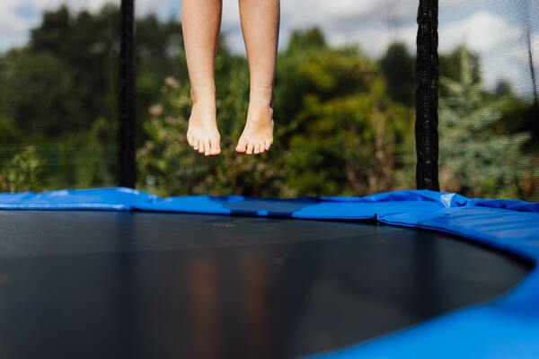 Kid jumping on a trampoline in a park