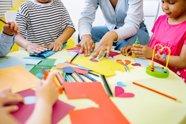 Kids sitting around a table doing arts and crafts