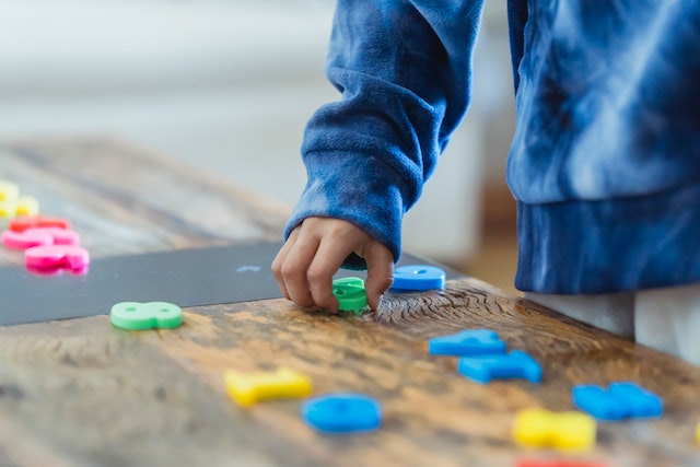 Child playing with letters and alphabets on a table