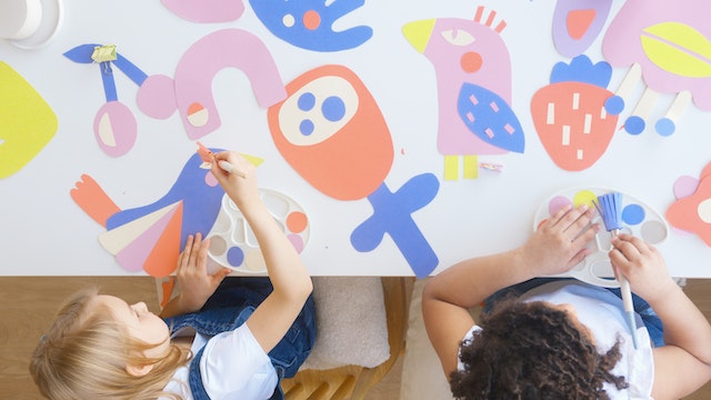 Overhead view of two girls creating a collage